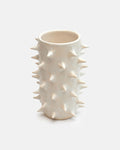 White ceramic vase with spiky texture on a white background