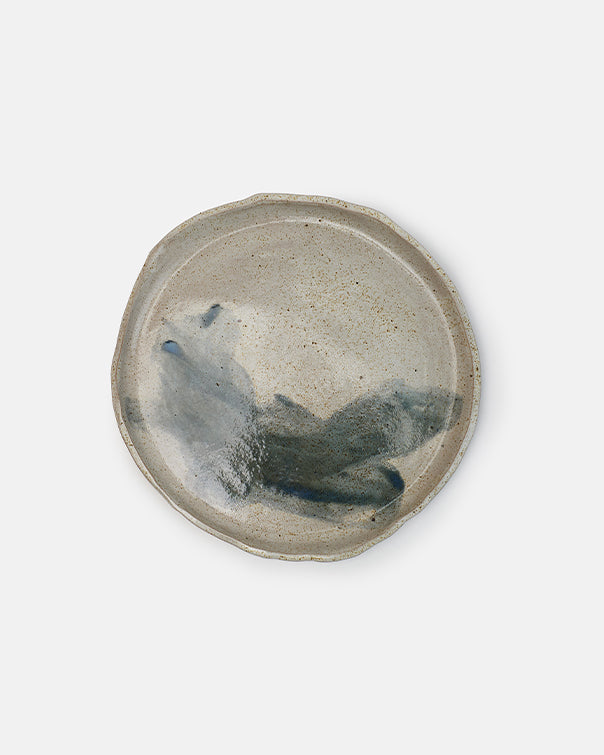 Ceramic plate with a textured surface and blue accents on a white background