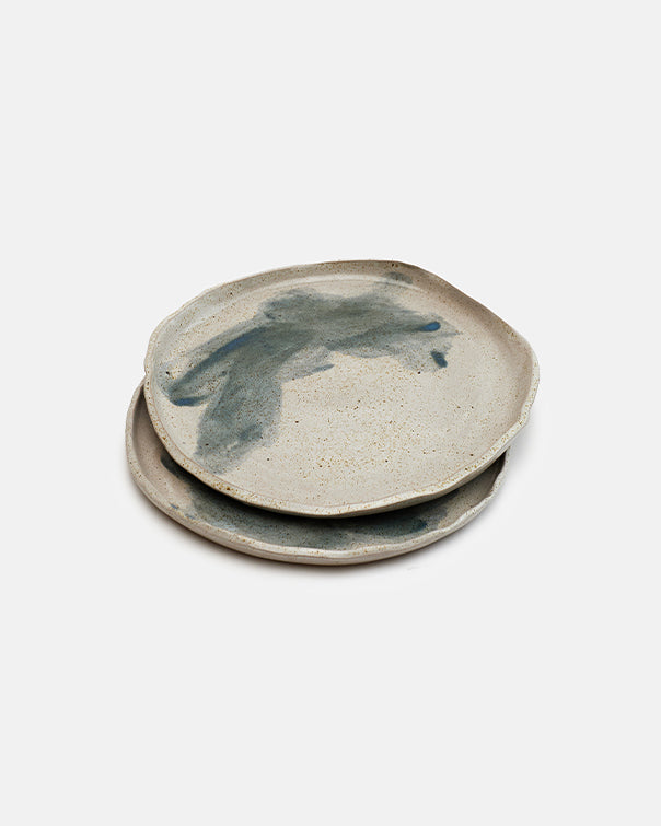 Two ceramic coasters with a handprint design on a white background