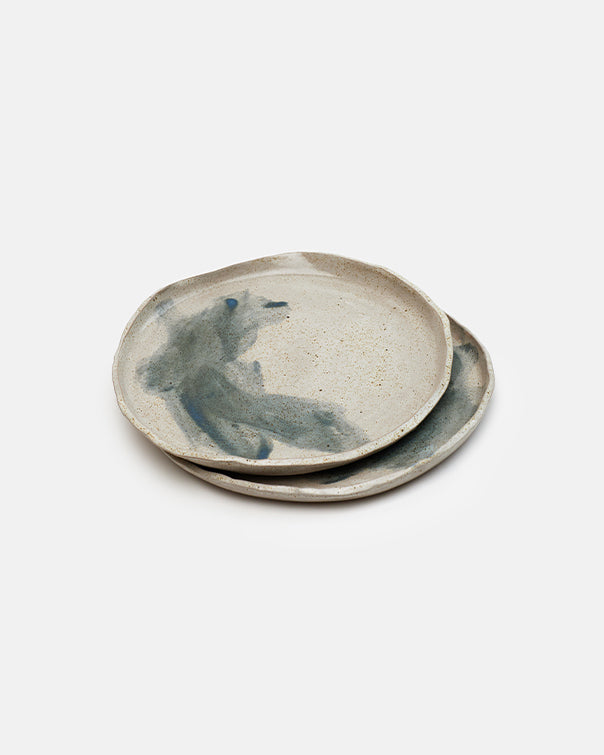 Two ceramic plates with abstract designs on a white background
