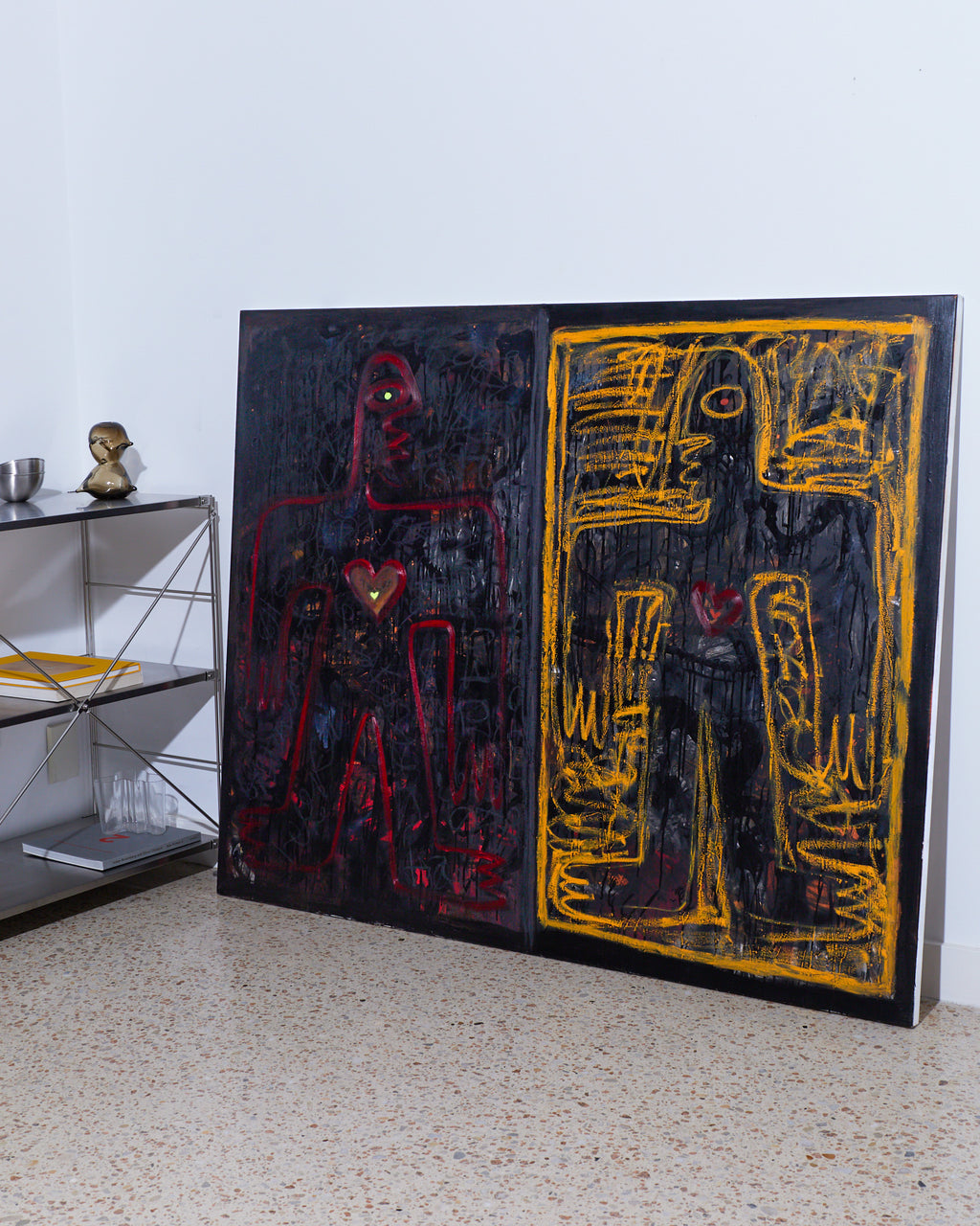 Abstract artwork with black, red, and yellow colors on a white wall.