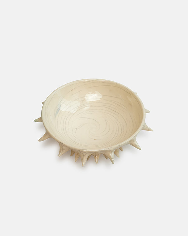 Ceramic bowl with spiky rim on a white background