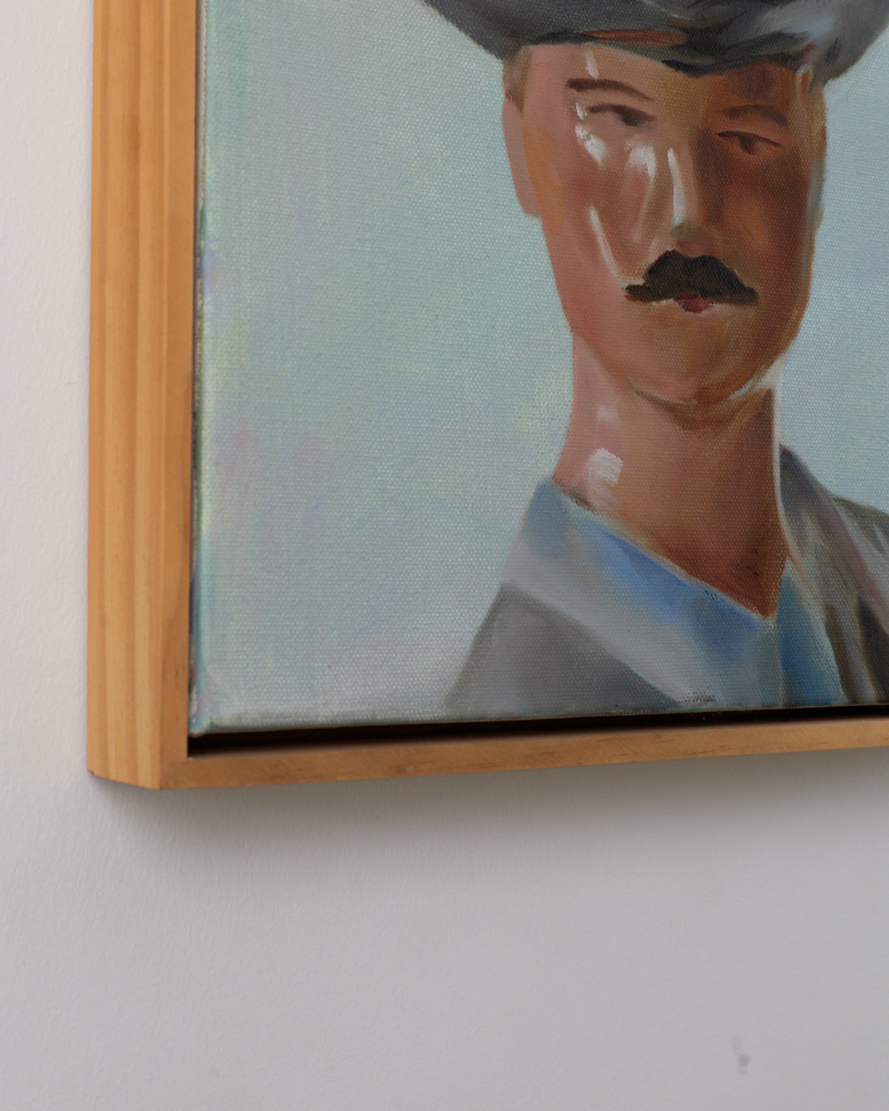 Framed portrait of a man with a mustache on a white wall