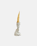Candle in a textured stone holder on a white background