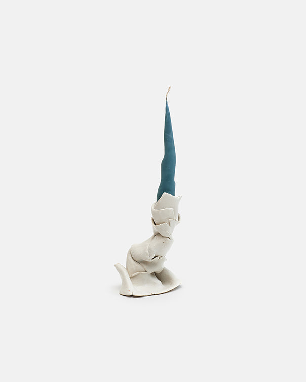 White ceramic cat figurine with a blue ribbon on a white background
