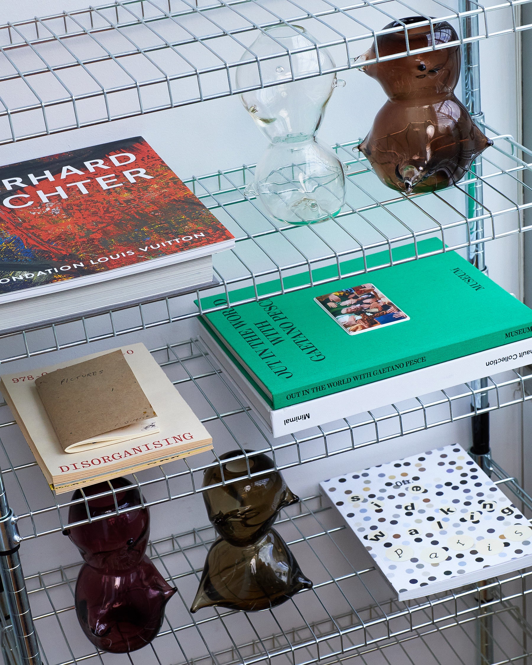 Metal wire shelf with books, decorative items, and a small figurine