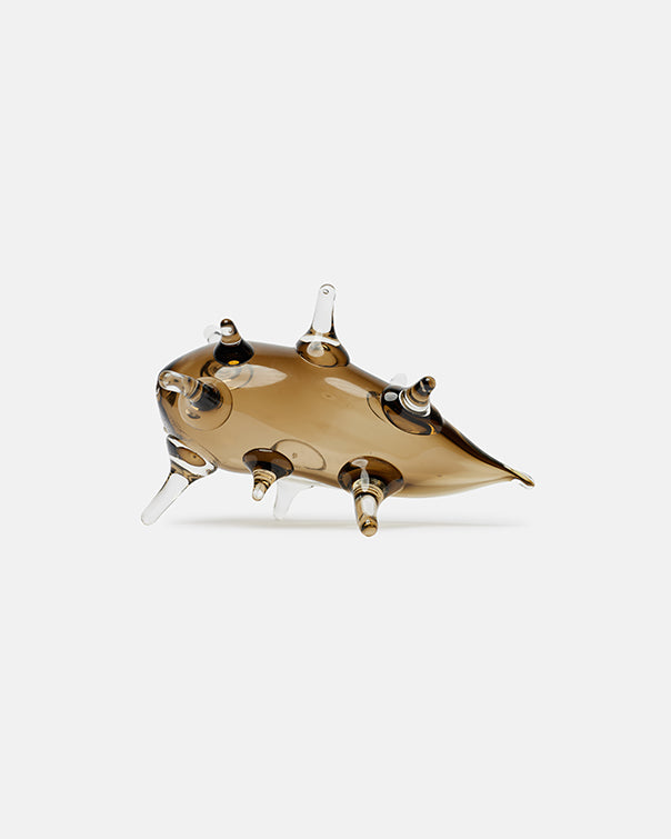 Gold-colored sculpture of a futuristic vehicle on a white background