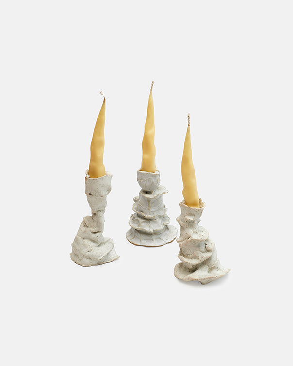 Three candle holders with candles on a white background