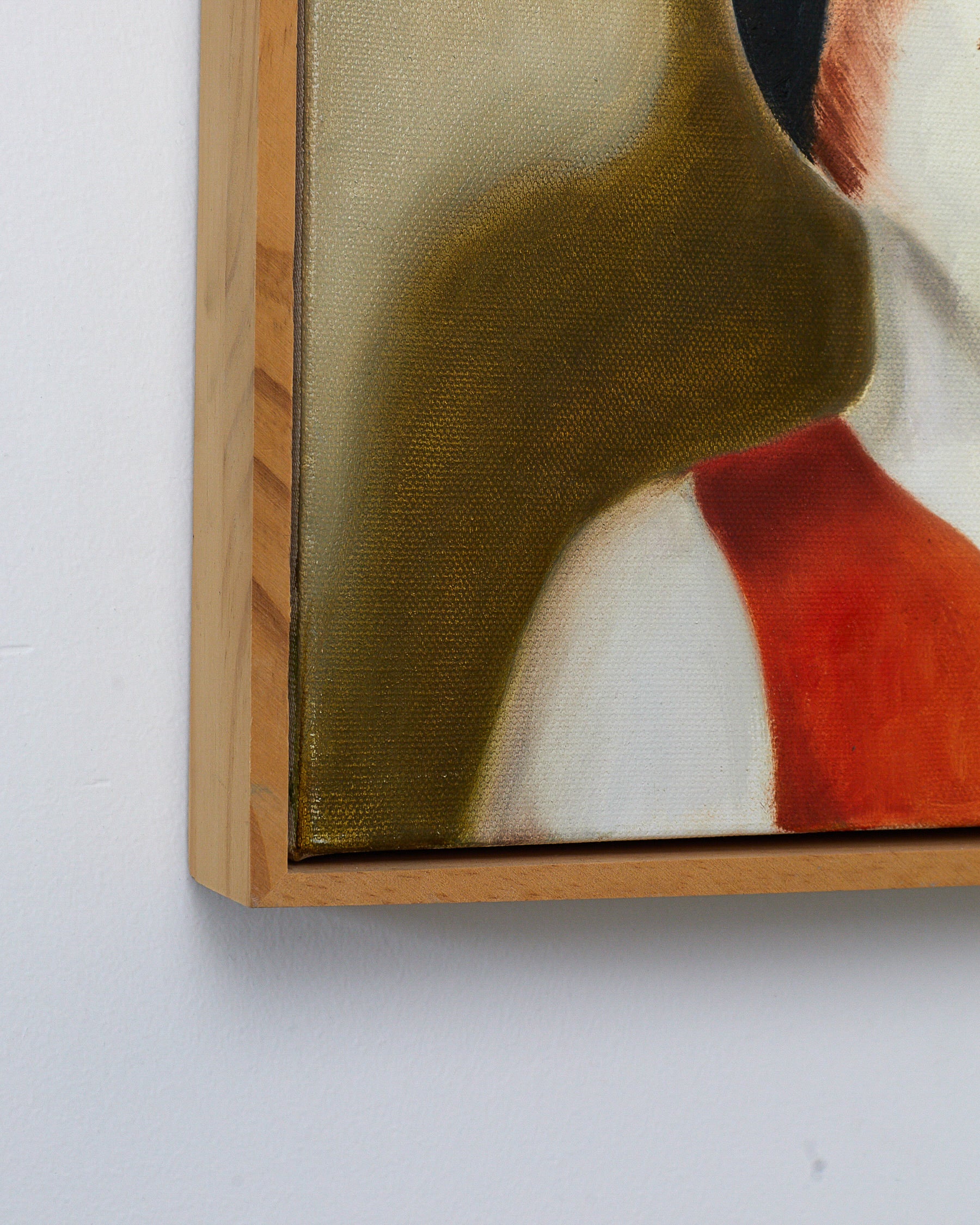 Framed artwork with a wooden border on a white wall