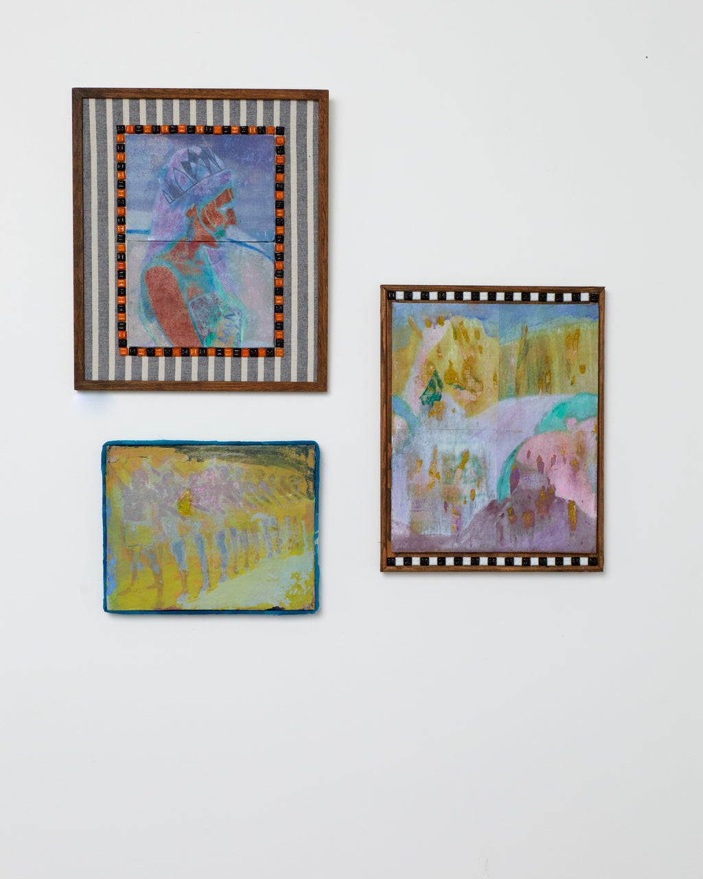 Three framed artworks on a white wall