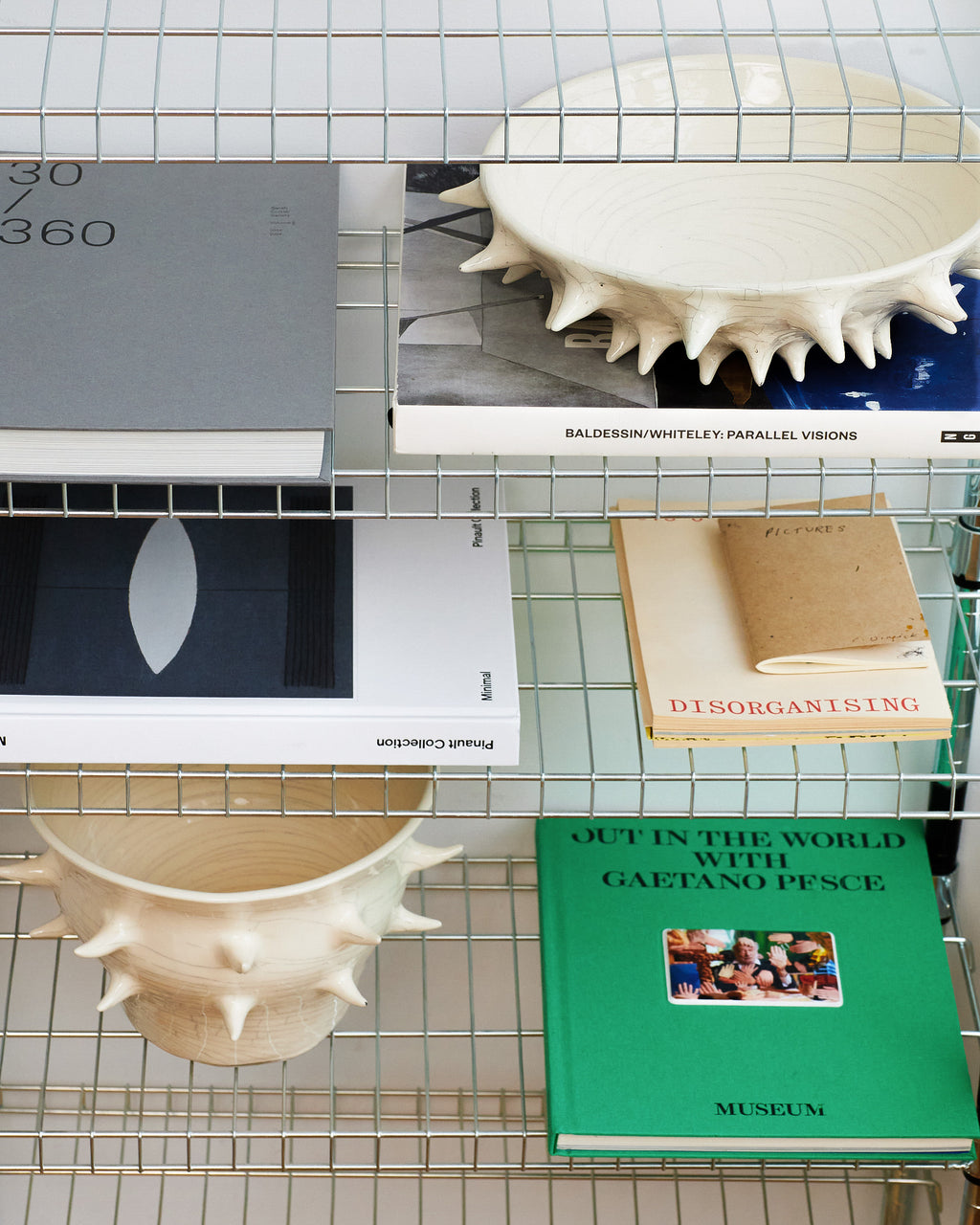 Collage of books and a sculpture on a grid background