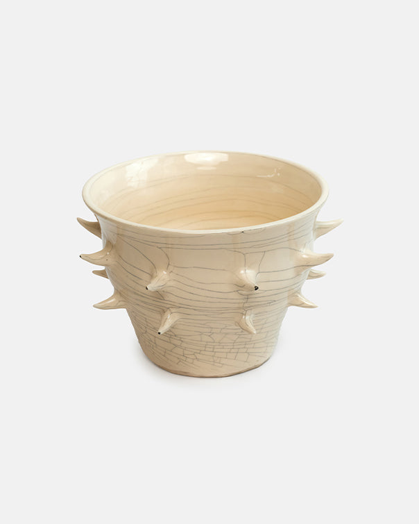 Ceramic cup with spiky design on a white background