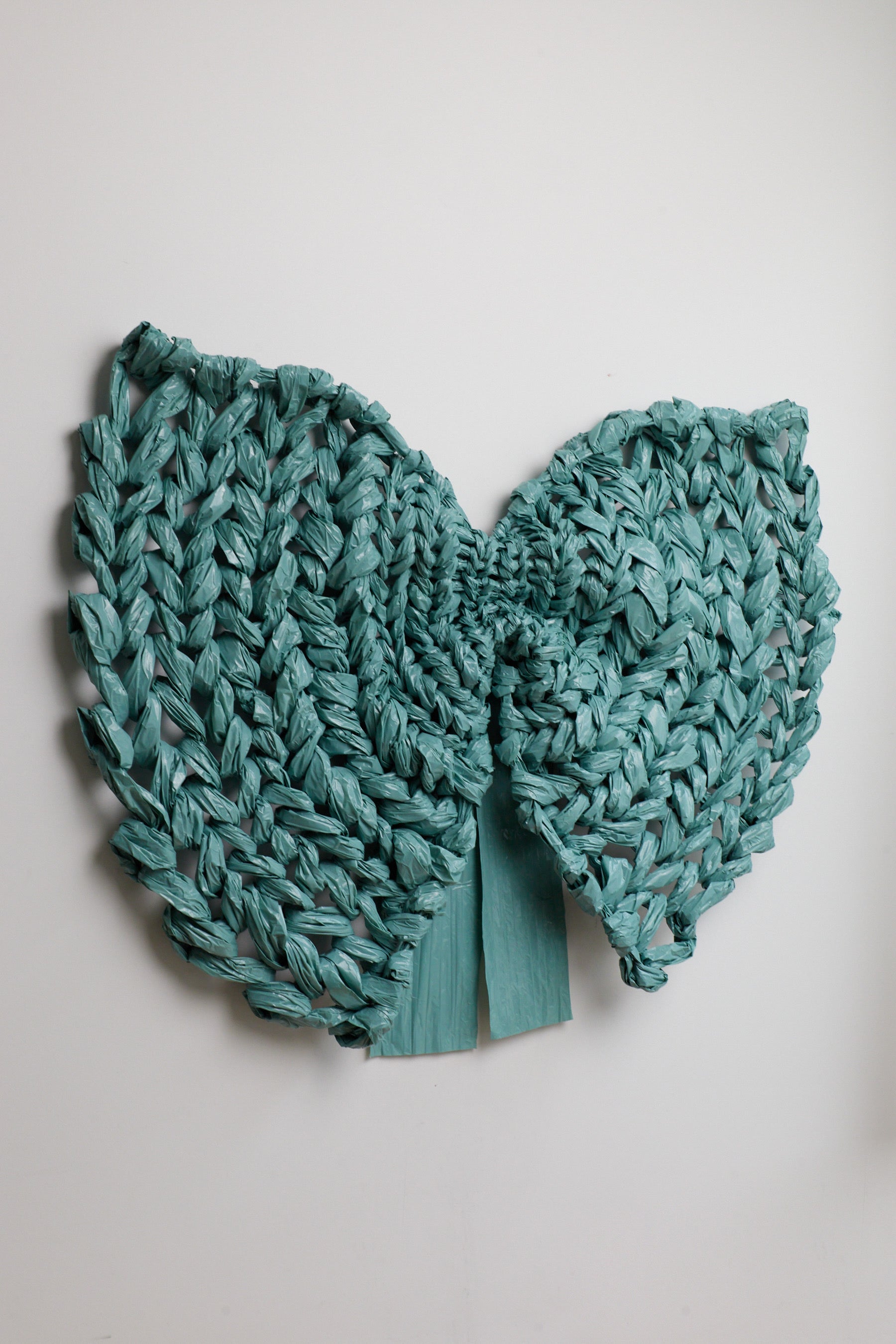 Teal knitted item on a light gray background
