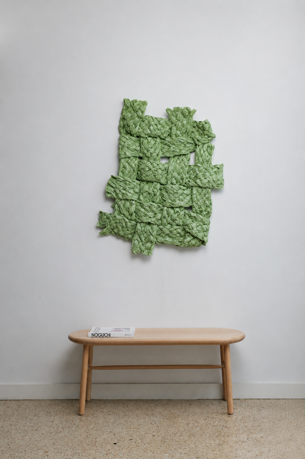 Green abstract wall art above a wooden table with a white wall background