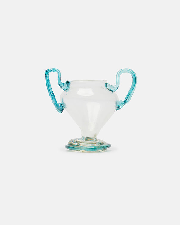 Clear glass cup with turquoise handles on a light gray background