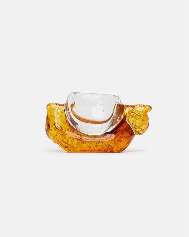 Decorative glass object with a clear center and amber-colored base on a white background
