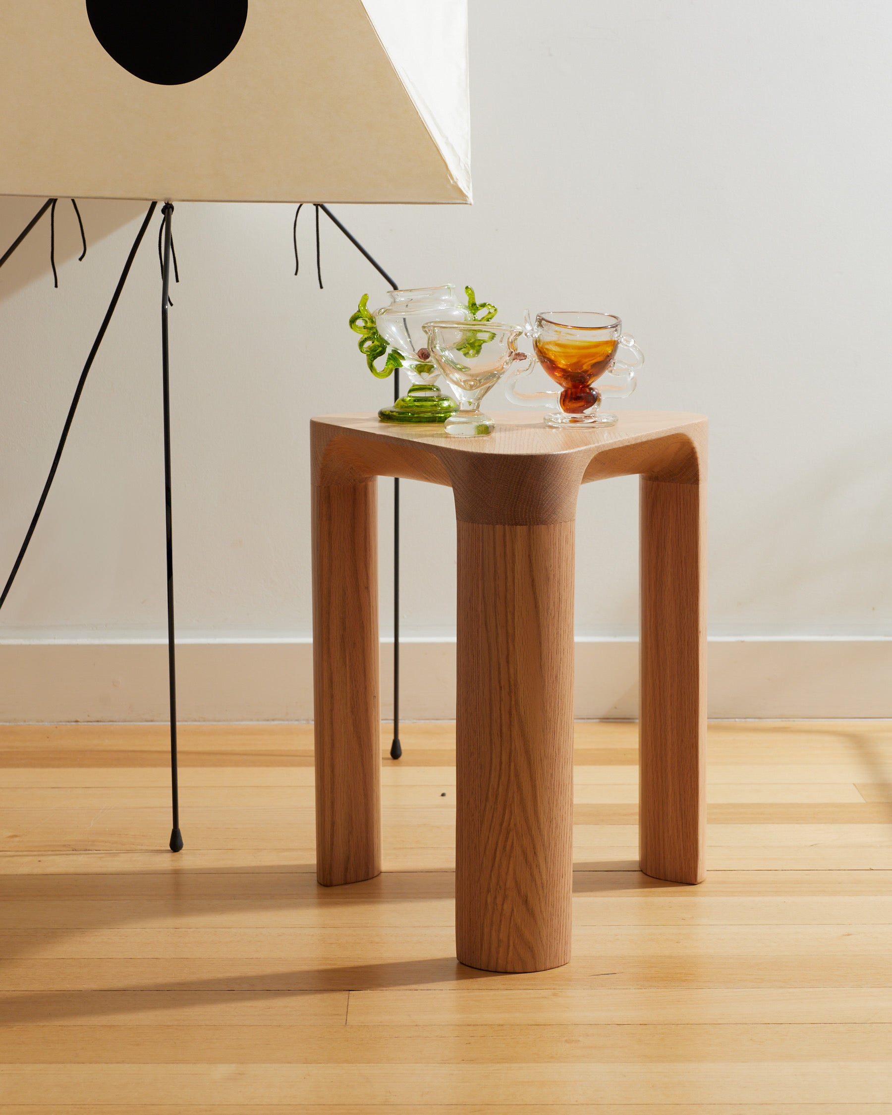 Wooden side table with glass cups on a wooden floor
