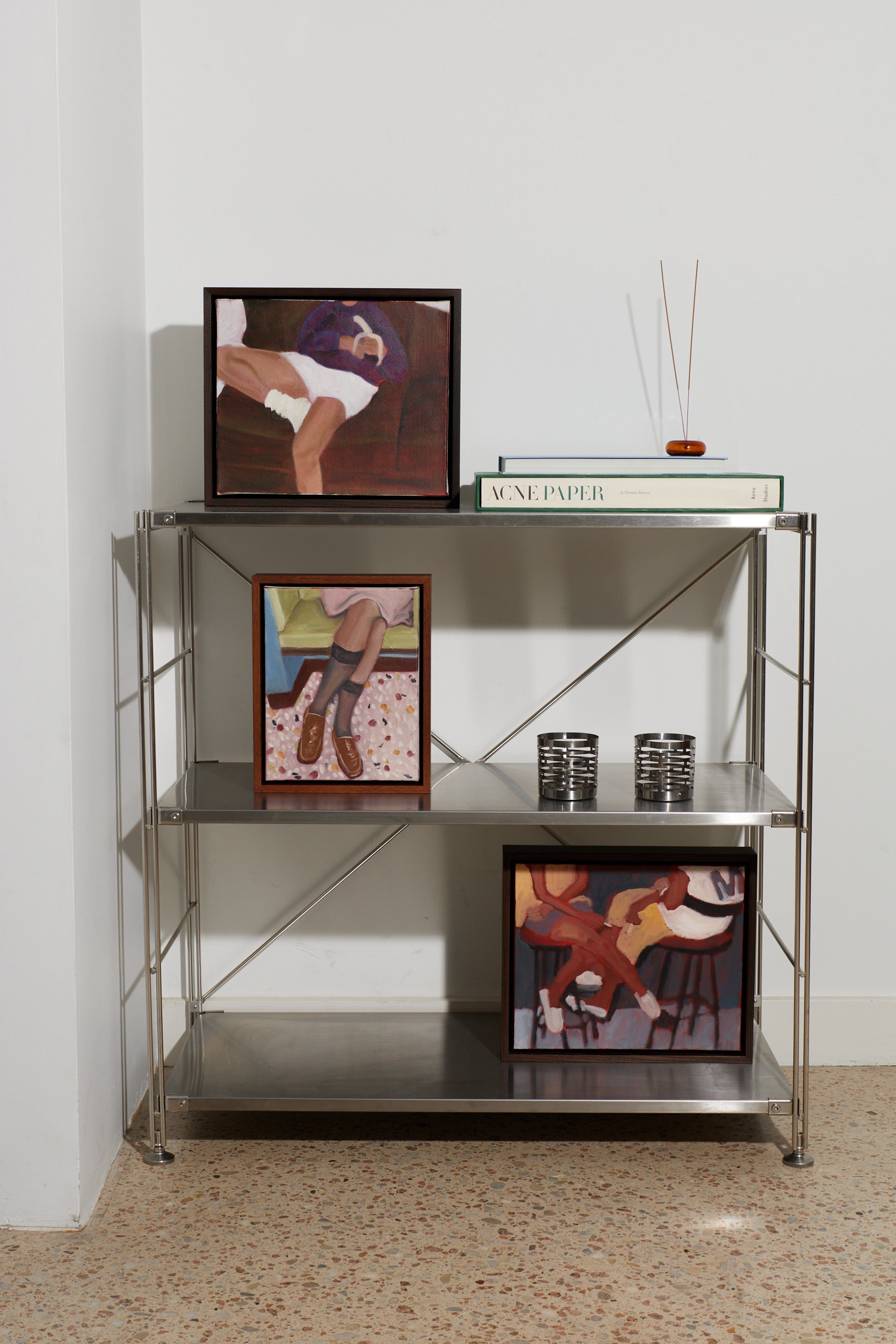 Metal shelving unit with decorative items against a white wall