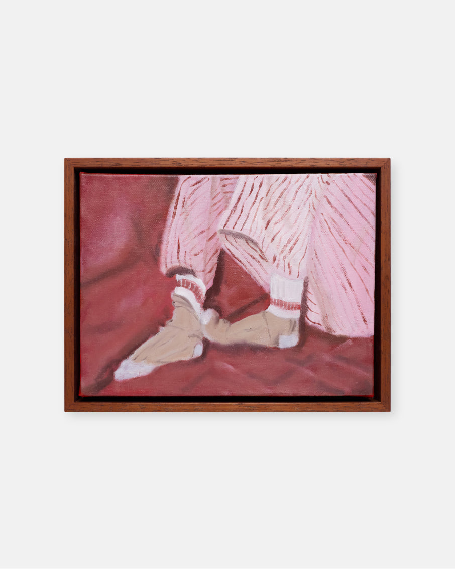 Framed artwork of a person wearing socks and pants on a red surface.