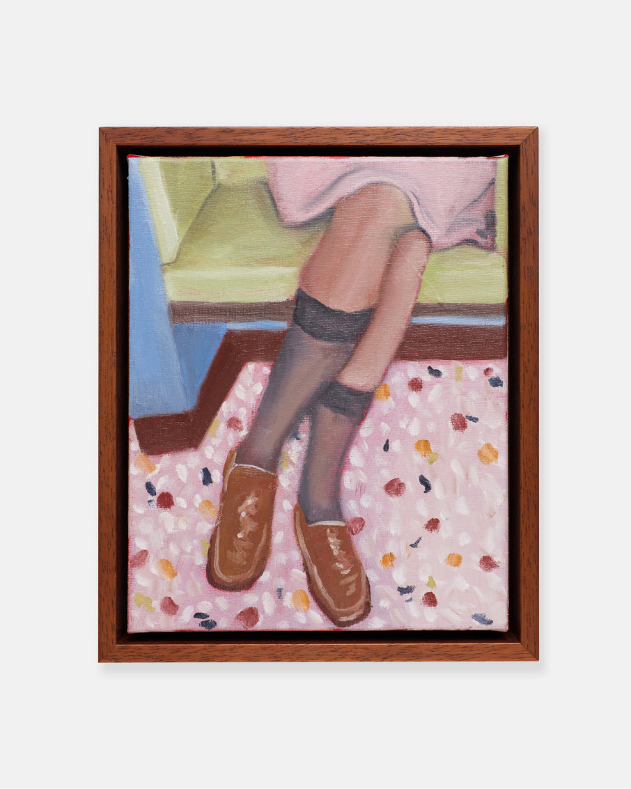 Framed artwork of a person's legs in socks and shoes on a floral surface.