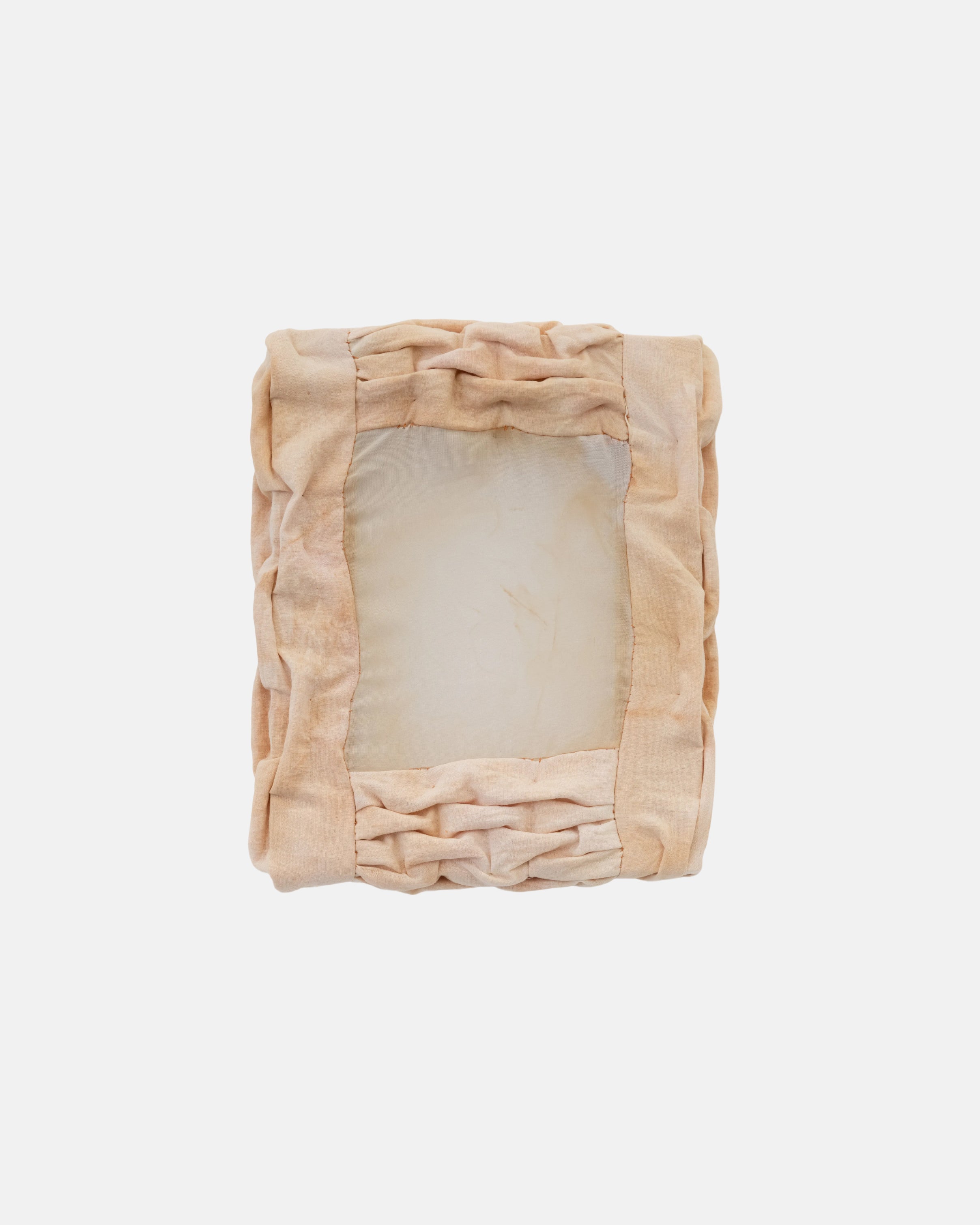 Folded beige blanket with ruffled edges on a light gray background