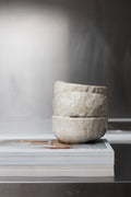 Stack of stone bowls on a magazine with a blurred background