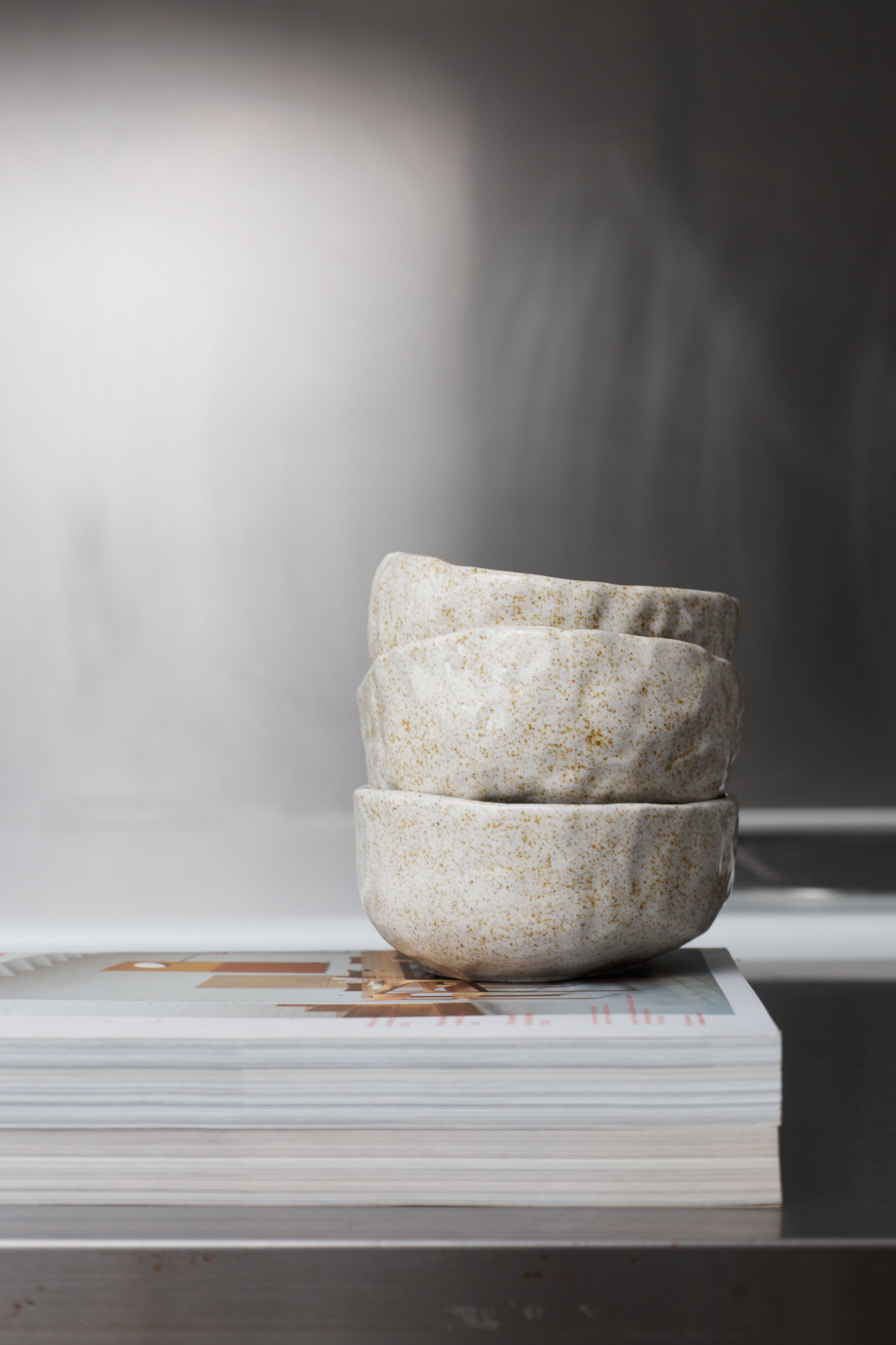 Stack of stone bowls on a magazine with a blurred background