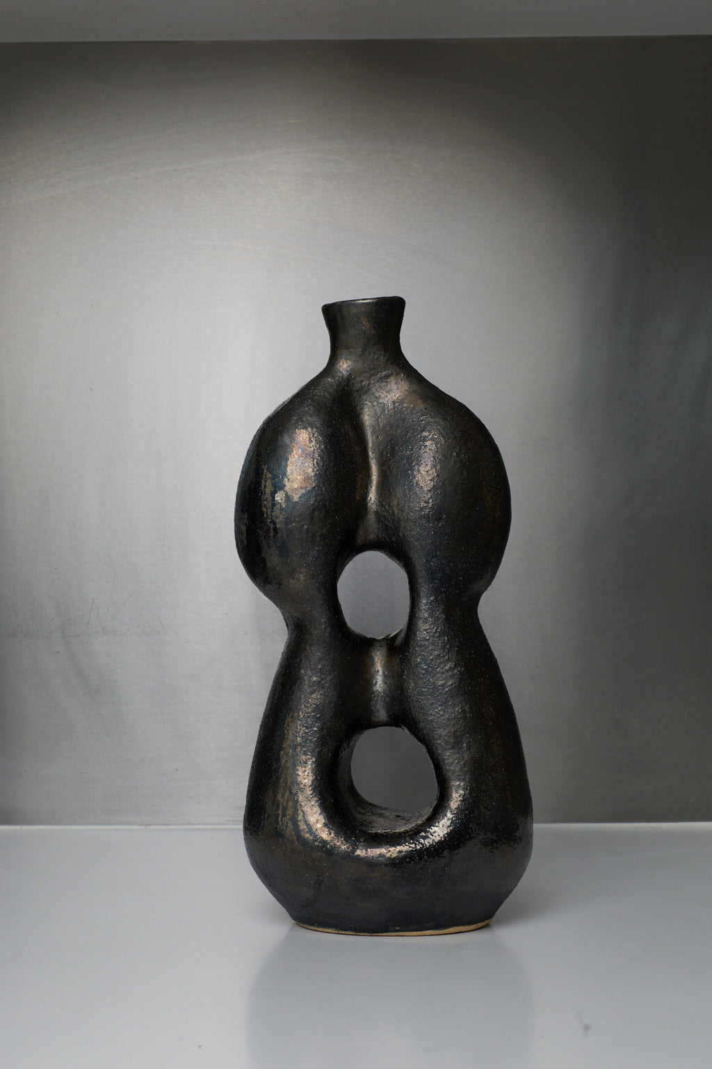 Black abstract vase on a gray background
