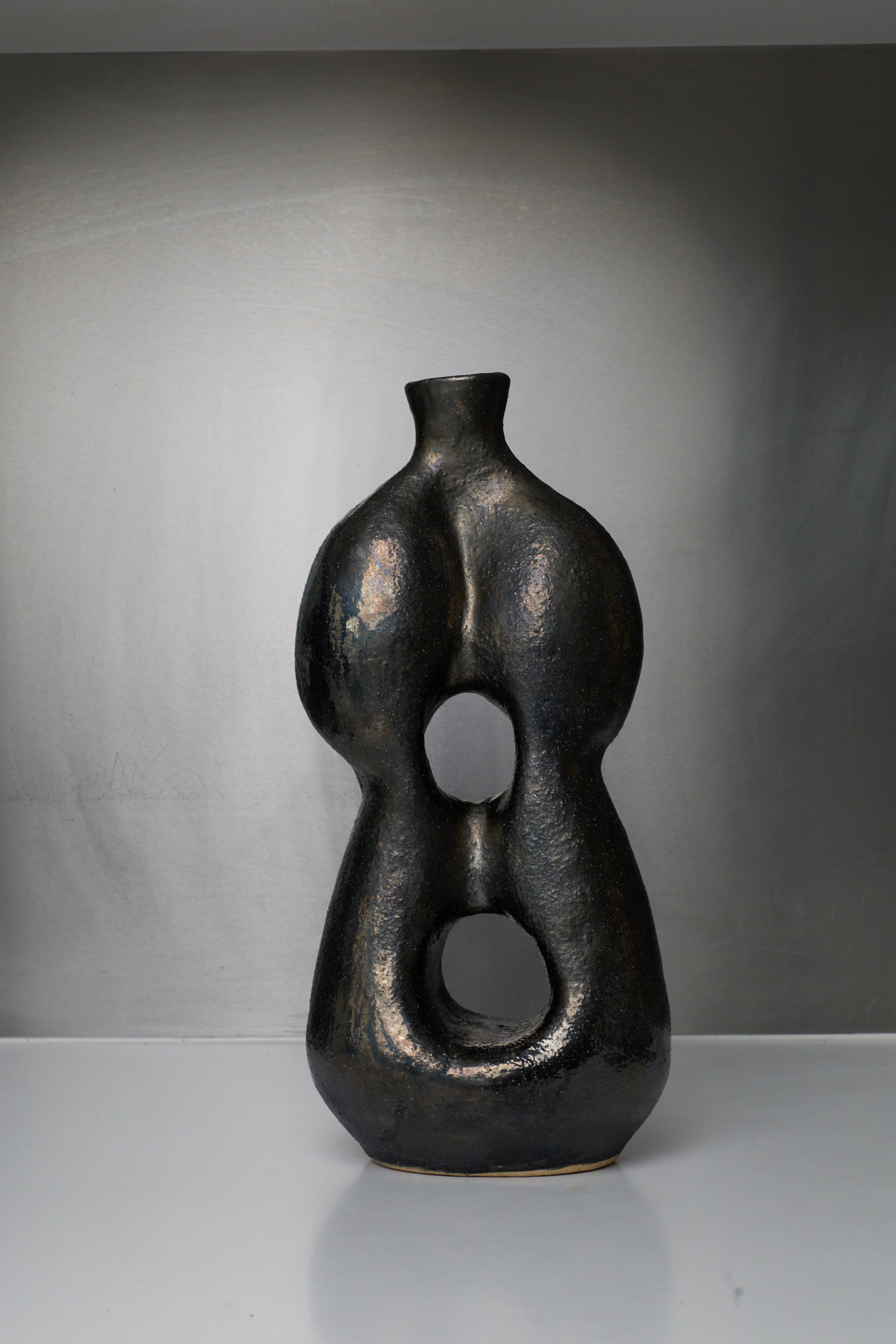 Black abstract vase on a gray background